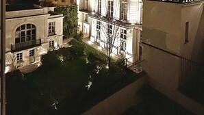 Een nachtzicht van een historisch gebouw met klassieke architectuur, waaronder gebogen ramen en een opvallende centrale toren.