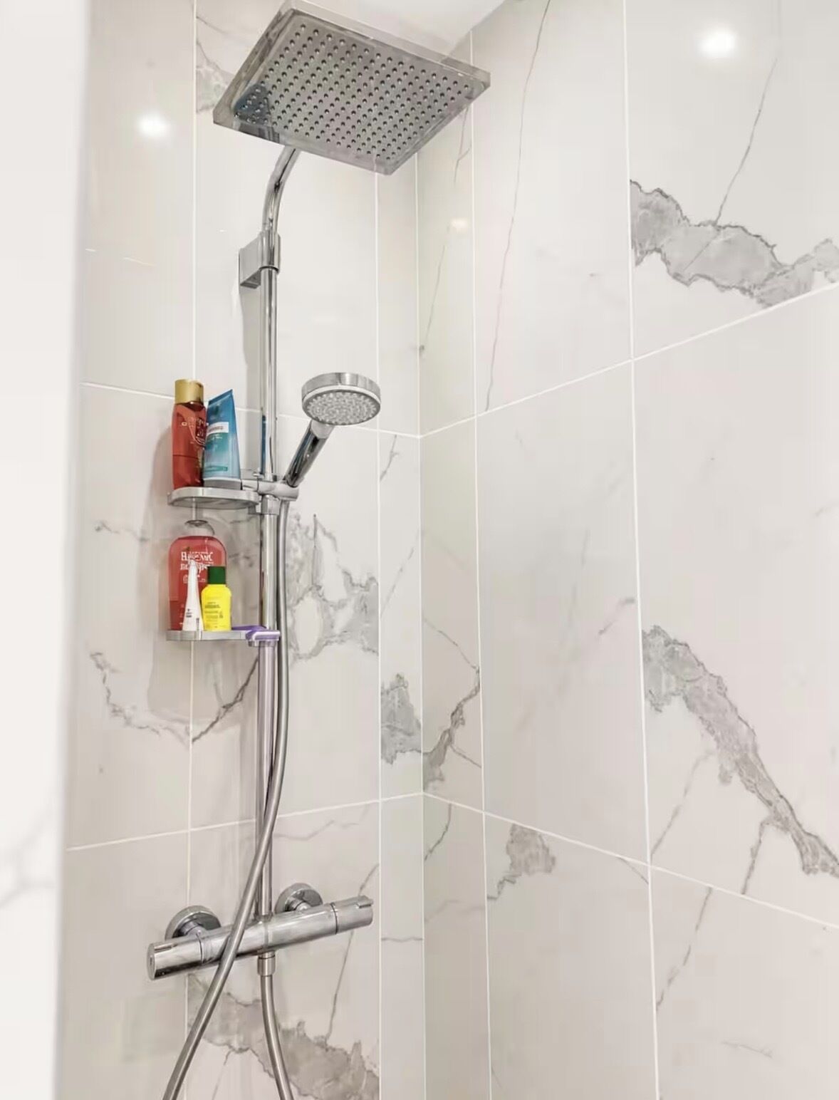 Eine Dusche mit Regendusche, Handbrause und Duschwandhalterung.