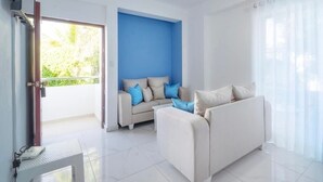 Una sala de estar moderna con un conjunto de sofá, una mesa de centro y un televisor.