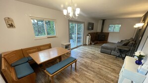 Un amplio salón con un banco de madera, una mesa de comedor y una chimenea.