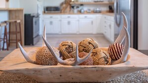 Een houten dienblad met gevlochten ballen en gewei in een moderne keuken.
