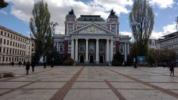 A large, historic building with a grand facade, columns, and statues.
