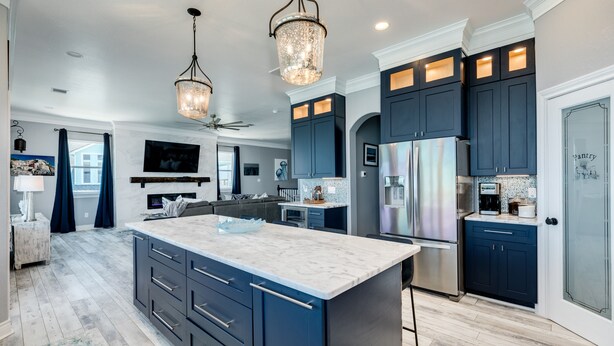 A modern kitchen with dark cabinets, a large island, stainless steel appliances, and pendant lighting. - Beachfront Luxury Retreat – Oceanfront, Family & Pet-Friendly Paradise (Freeport)