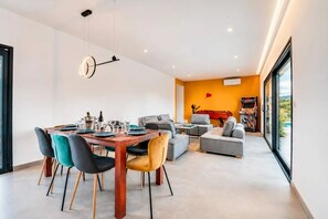 Een modern interieur met een eethoek, banken en een gameconsole.
