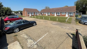 A two-story brick building with a parking area in front.