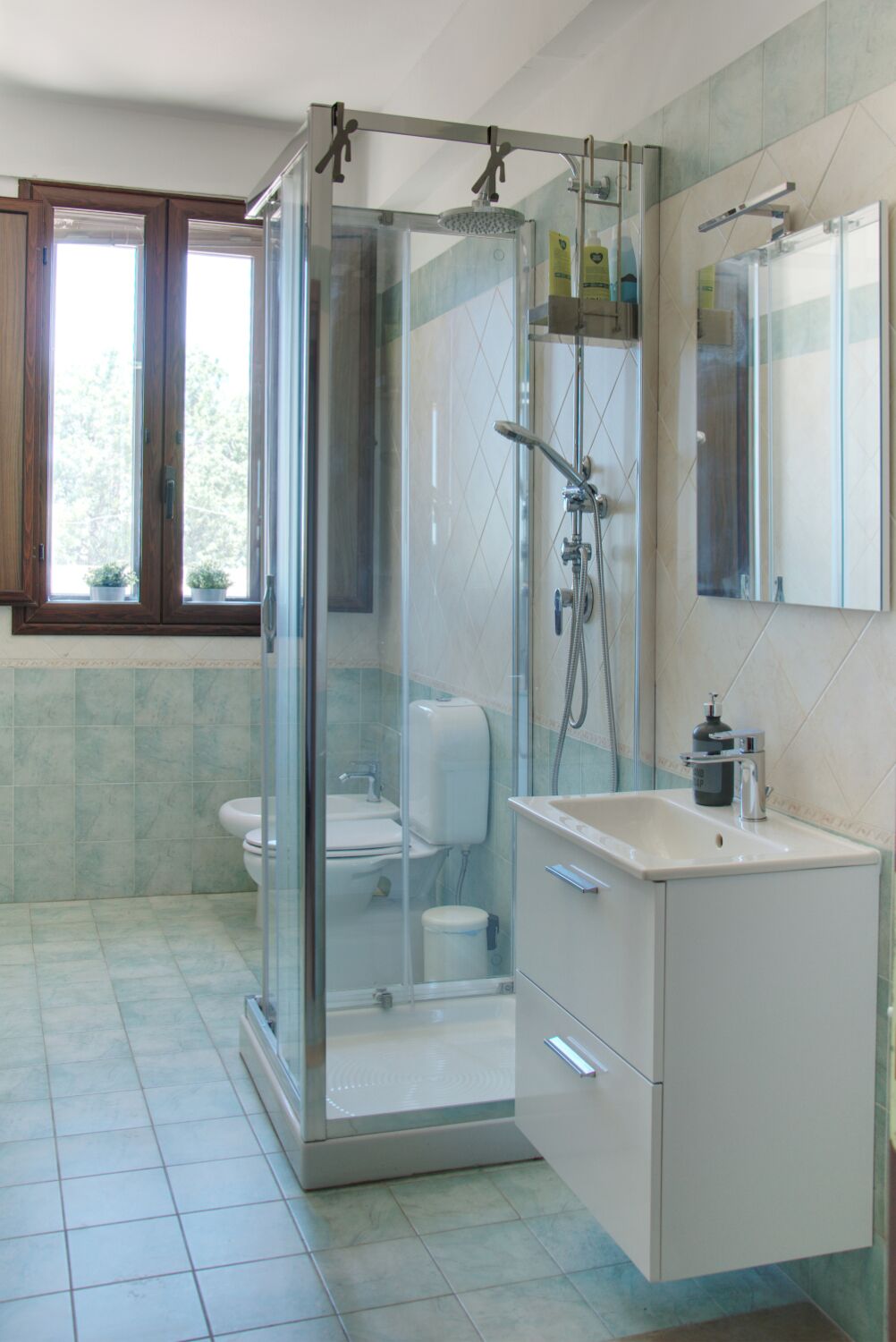 A modern bathroom with a glass-enclosed shower, a toilet, and a sink with a mirror above it.
