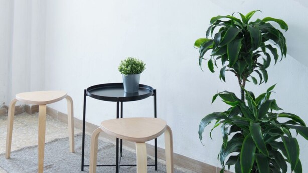 A small, enclosed outdoor area with a staircase, a round table with two stools, and a potted plant. - Le Stanze di Archimede (Syracuse)