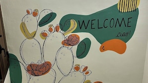 A staircase with a wall mural featuring cacti and a 'WELCOME' sign. - Le Stanze di Archimede (Syracuse)