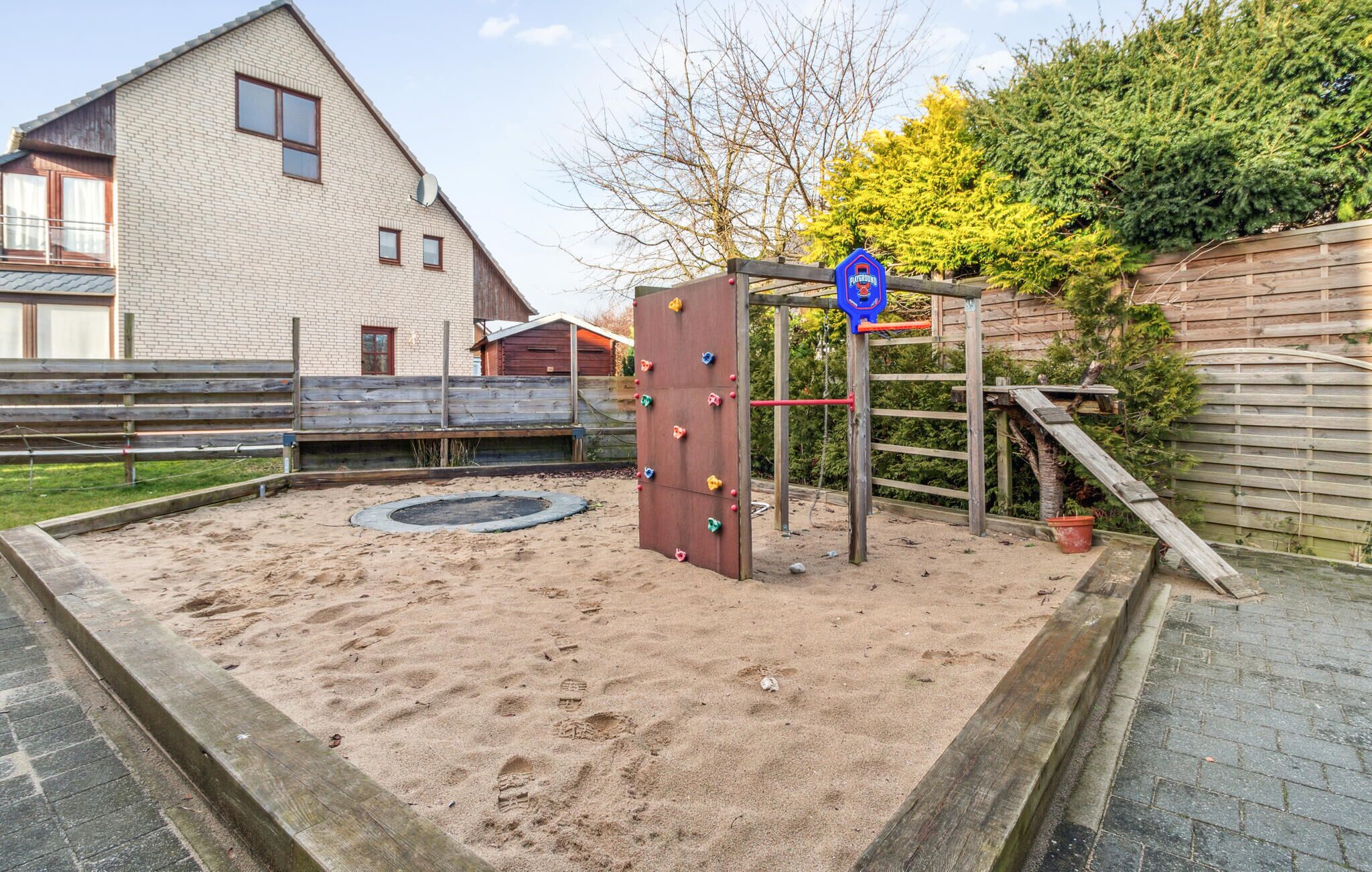 A playground with a climbing structure and a sandpit.