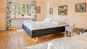 Una camera da letto con un letto, un comodino, una lampada e una finestra con tende.