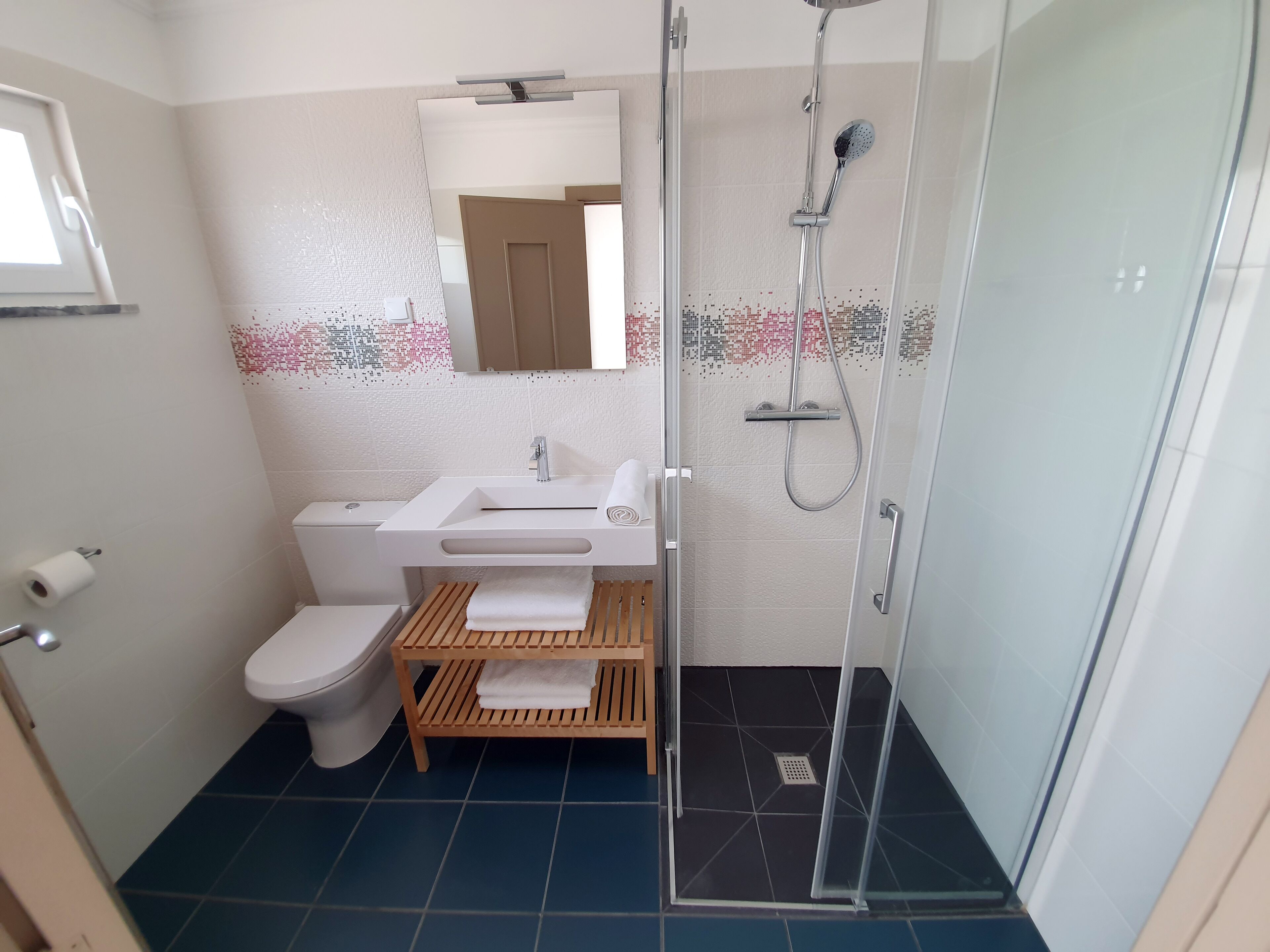 A bathroom with a toilet, sink, and shower.