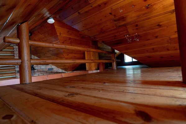 An attic space with wooden beams and a sloped ceiling.