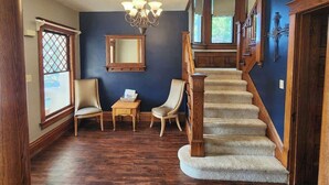 Un escalier avec des rampes en bois et des marches recouvertes de moquette, menant à l’étage supérieur.