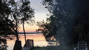 Un foyer extérieur avec vue sur un lac au crépuscule.