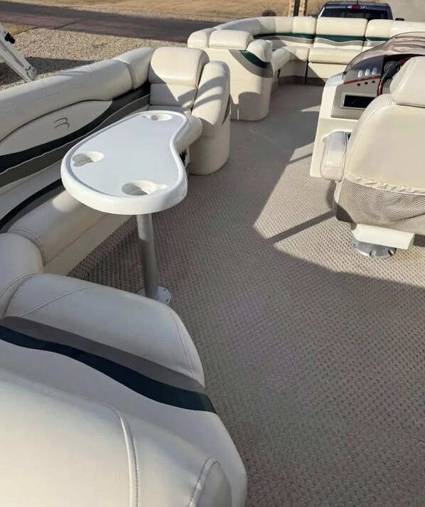 Interior de barco con asientos y una pequeña mesa.