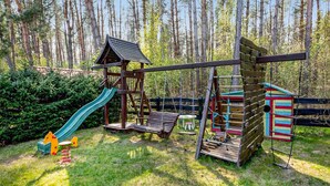 A playground with a slide, swings, and climbing structures in a forested area. - Gorgeous apartment in Debina with WiFi (Debina)
