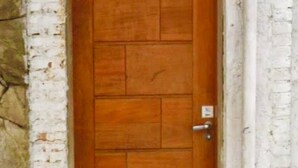 Eine Holztür mit einem Schild darüber, auf dem 'Vila Crejo Guest House' steht.