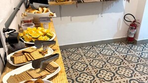 Ein Frühstücksbuffet mit verschiedenen Backwaren, Früchten und Getränken.