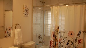 Ein Badezimmer mit Toilette, Waschbecken, Badewanne und Duschvorhang.