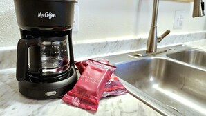 A coffee maker labeled "Mr. Coffee" and two packets of coffee on a kitchen counter. - Fireweed 2 Bedroom by airport; lakes, trails, fishing, skiing, hiking! (Anchorage)