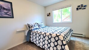 A bedroom with a bed, a window, and a picture on the wall. - Fireweed 2 Bedroom by airport; lakes, trails, fishing, skiing, hiking! (Anchorage)