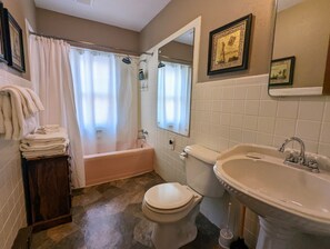 Une salle de bain avec une baignoire, des toilettes et un lavabo.