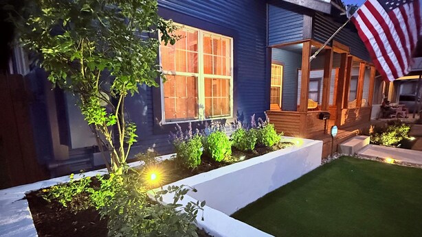 A modern house with a well-maintained lawn and garden beds.