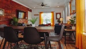 A dining area with a wooden table, black chairs, and a ceiling fan.