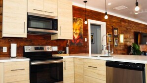 A modern kitchen with wooden cabinetry, stainless steel appliances, and pendant lighting.