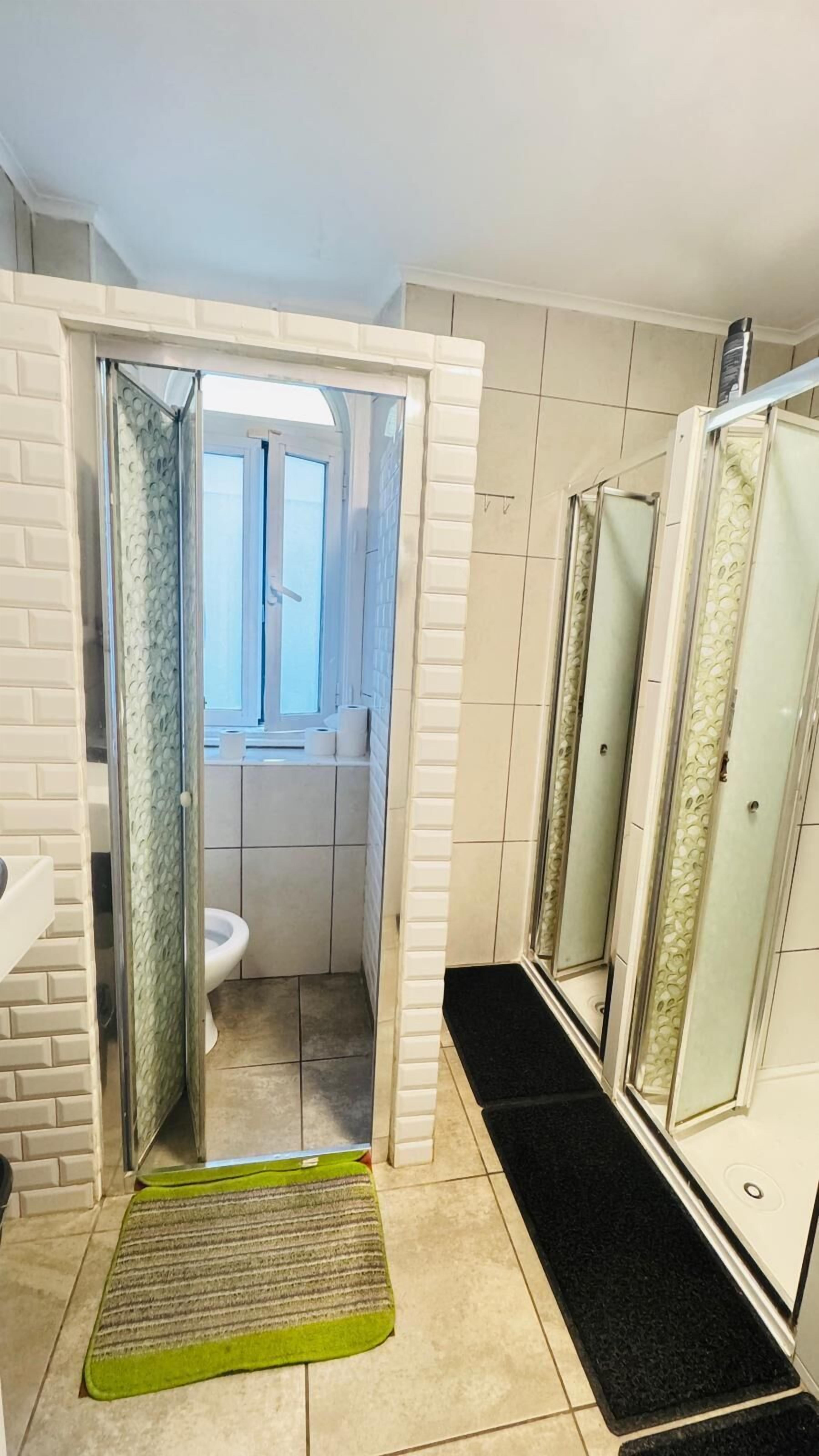 A bathroom with a shower, toilet, and sink.