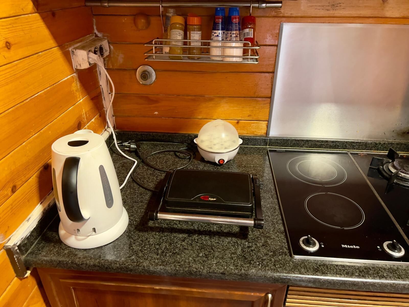 A kitchen with a stove, a kettle, and a coffee maker.