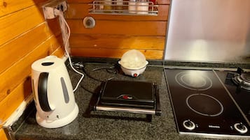A kitchen with a stove, a kettle, and a coffee maker.