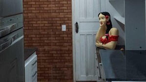 Una cocina pequeña con pared de ladrillo, una puerta blanca y un maniquí.