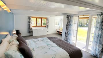 Ein Schlafzimmer mit einem großen Bett, einem Schminktisch und einem Fenster mit Vorhängen.