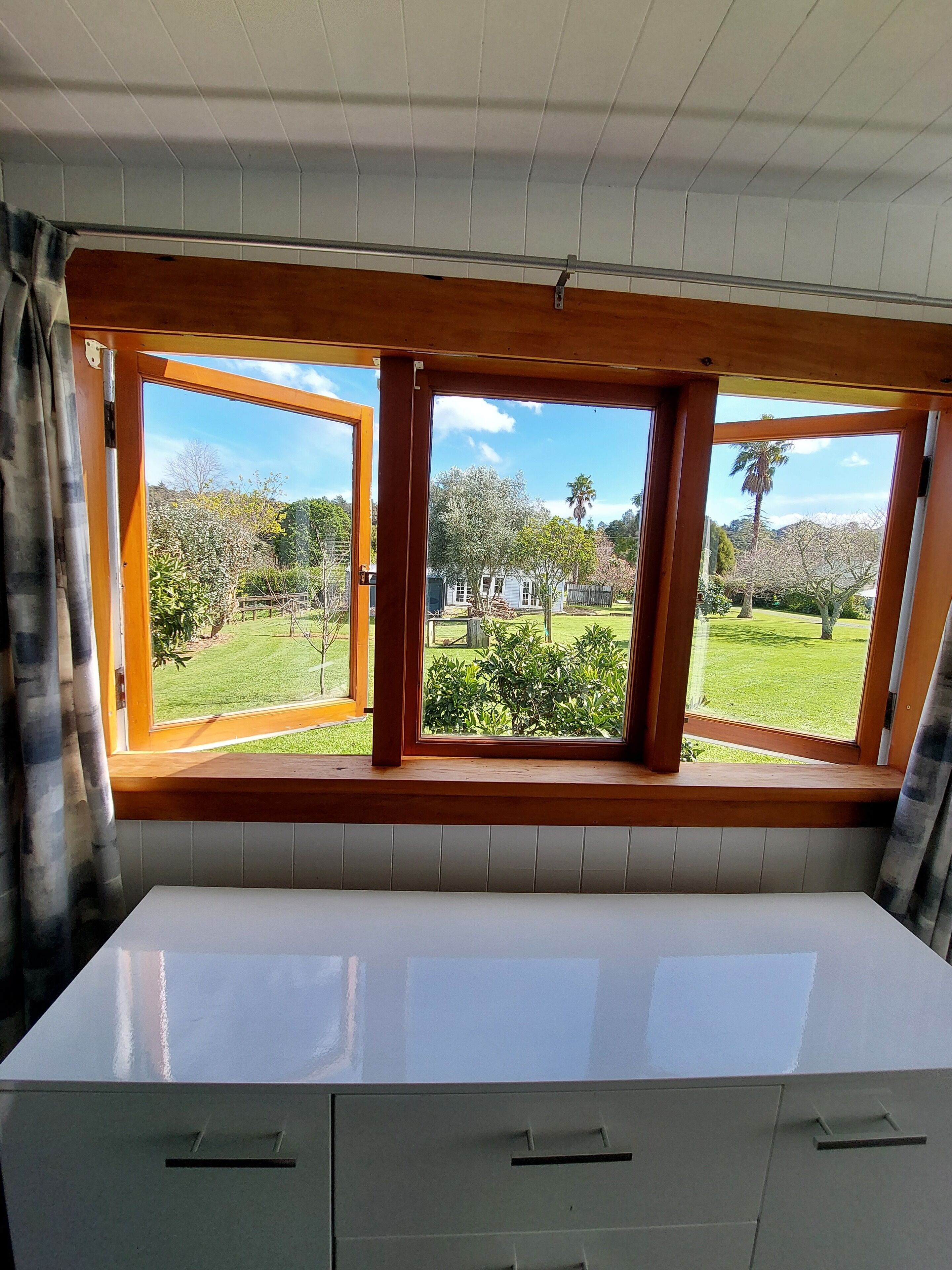 Ein Zimmer mit großem Fenster und Blick auf einen Garten.