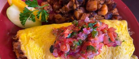 Un plato con tortilla, carne guisada y un adorno de perejil.