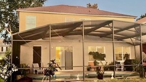 A house with a covered patio, a swimming pool, and a garden. - Family house in Kissimmee. (Kissimmee)