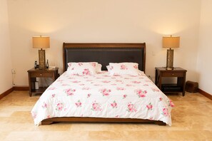 Habitación estándar de hotel con una cama grande, dos mesitas de noche y lámparas.