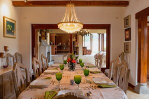 A dining room with a long table set for a meal, surrounded by chairs.
