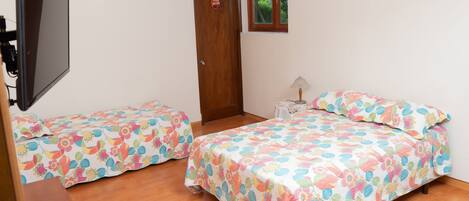 Un dormitorio con dos camas, un televisor y una puerta que indica 'Puff Room'.