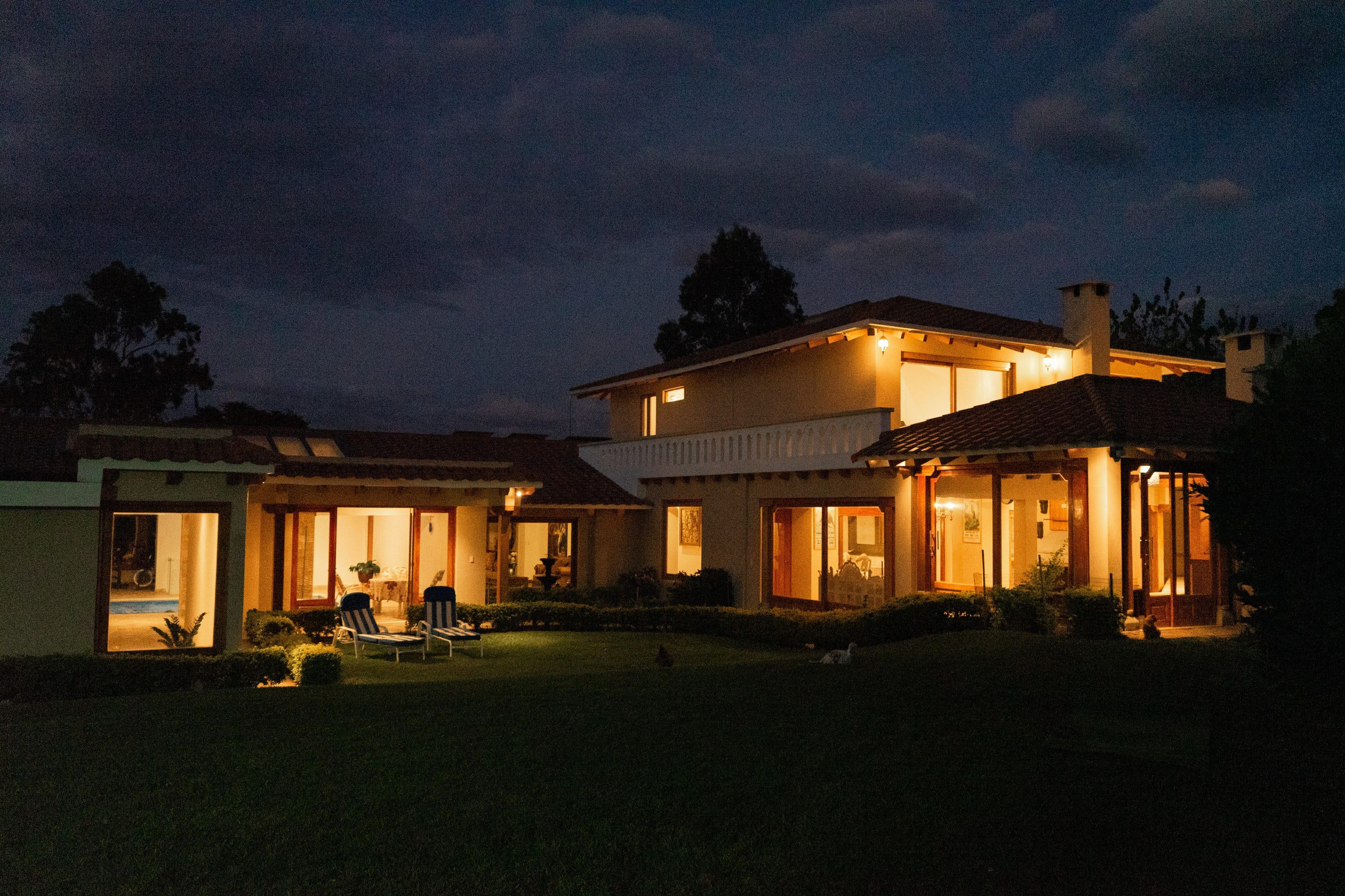 A two-story house with a well-lit front porch and a visible garage.