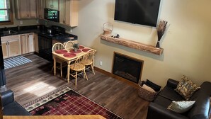 A compact living space with a kitchen, dining area, fireplace, and seating area. - Cozy cabin Peaceful Side, Townsend, TN, Laurel Valley,  no steep roads (Townsend)