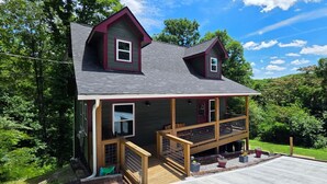A two-story house with a balcony, a front porch, and a garage. - Cozy cabin Peaceful Side, Townsend, TN, Laurel Valley,  no steep roads (Townsend)