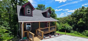 A two-story house with a balcony, a front porch, and a garage. - Cozy cabin Peaceful Side, Townsend, TN, Laurel Valley,  no steep roads (Townsend)