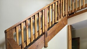 A wooden staircase with a black leather couch at the bottom. - Cozy cabin Peaceful Side, Townsend, TN, Laurel Valley,  no steep roads (Townsend)