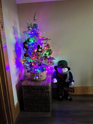 A Christmas tree with colorful lights and ornaments, placed on a woven basket. - Cozy cabin Peaceful Side, Townsend, TN, Laurel Valley,  no steep roads (Townsend)