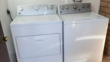Eine Waschmaschine und ein Trockner in einem Gerät mit Bedienelementen und eingestecktem Stromkabel.