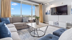 Un salon moderne avec un canapé, une table basse et un téléviseur.