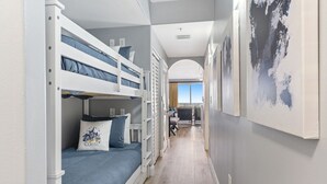 Une chambre d’hôtel avec un lit superposé, un bureau et une vue sur l’extérieur.