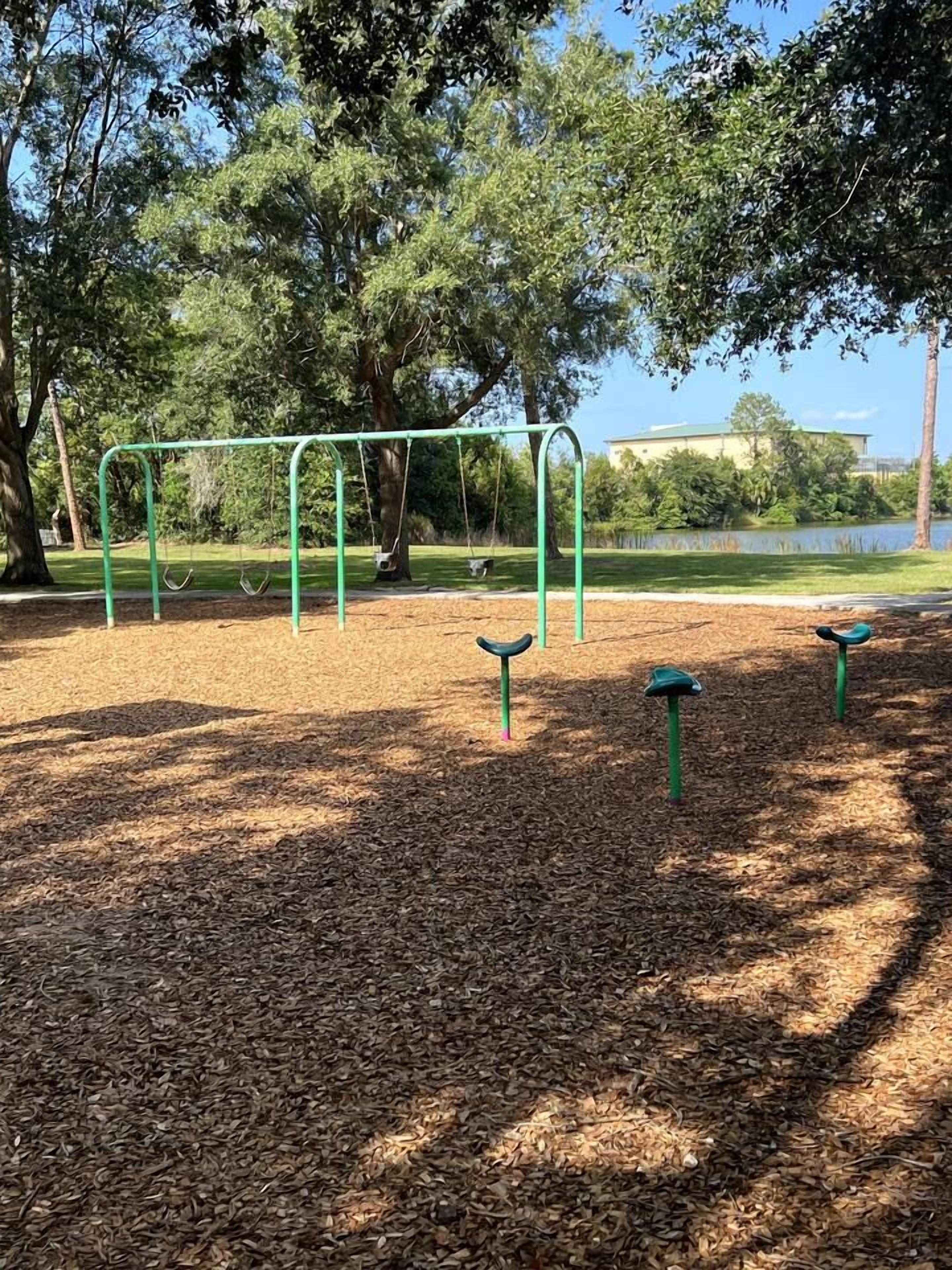 Um parque com baloiço e gangorra.
